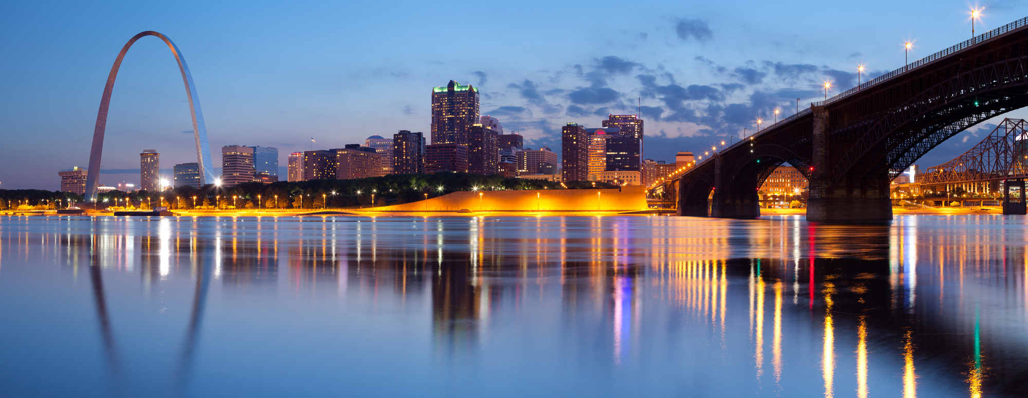 Panoramic photo of St Louis arch from the Mississippi River at dusk
